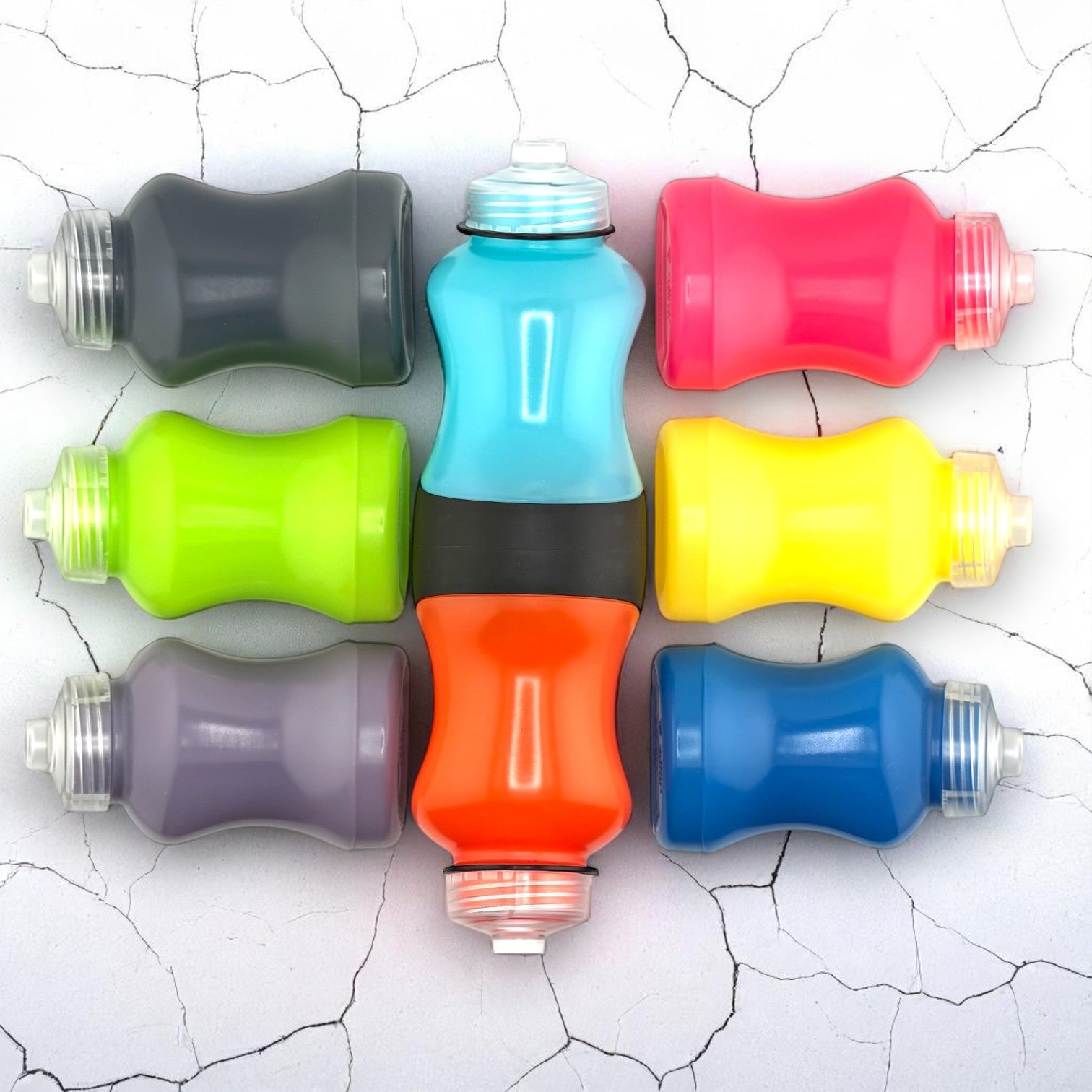 Image of blue and orange Swivel Bottle with 6 colorful flasks placed next to it on a cracked white background.